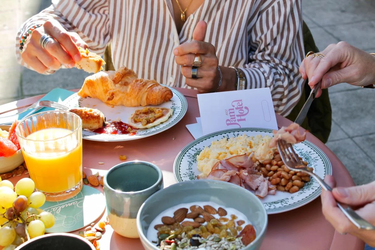 Petit-déjeuner en terrasse au Nice Pam Hotel : croissants, jus d'orange, œufs brouillés, bacon, fruits et granola – restaurant Pamela's, Nice