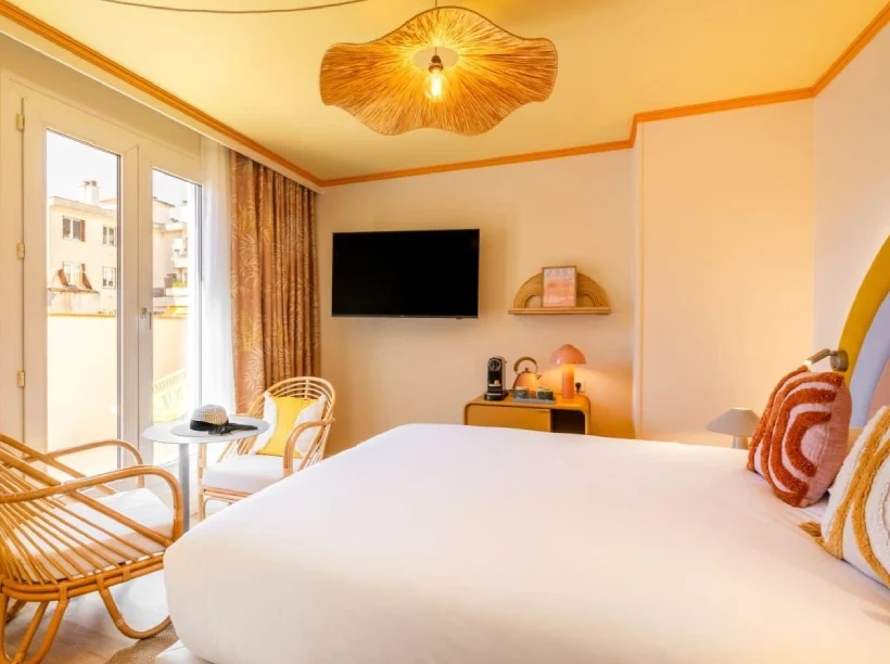 Chambre avec terrasse du Nice Pam Hotel à Nice, décorée dans un style rétro avec mobilier en rotin