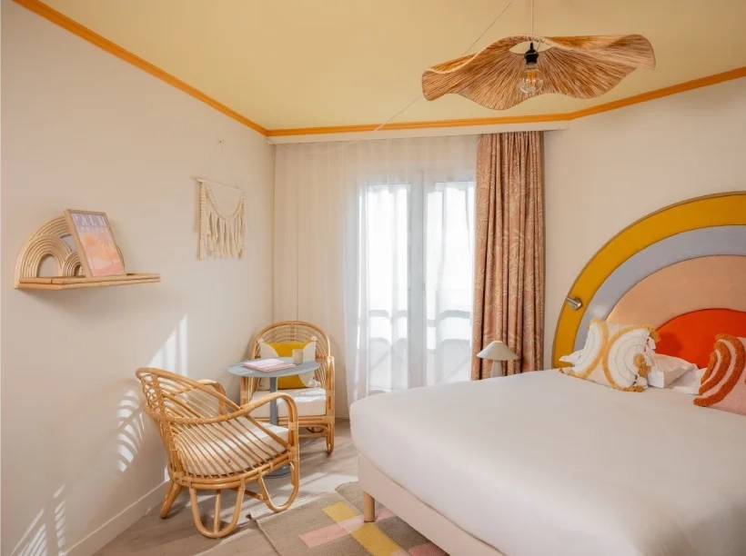 Chambre du Nice Pam Hotel à Nice avec décoration rétro en rotin et tête de lit colorée
